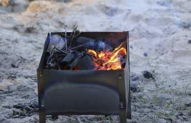 mangal yakıyor. mangal kömürü ile üzerinde yalan ızgara. Siyah kömür, çırpı, çam kozalakları yanma ve smoldering
