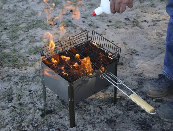 mangal yakıyor. mangal kömürü ile üzerinde yalan ızgara. kömürlerin güçlü yanma için özel sıvı ile sulanan.
