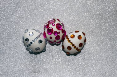 Paskalya kompozisyon flatlay. Paskalya yumurtaları Cam süsler ve inci boncuk gümüş bir arka plan üzerinde parlak rhinestones ile dekore edilmiştir.