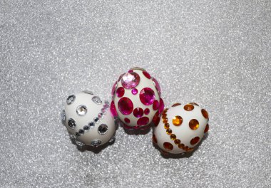 Paskalya kompozisyon flatlay. Paskalya yumurtaları Cam süsler ve inci boncuk gümüş bir arka plan üzerinde parlak rhinestones ile dekore edilmiştir.