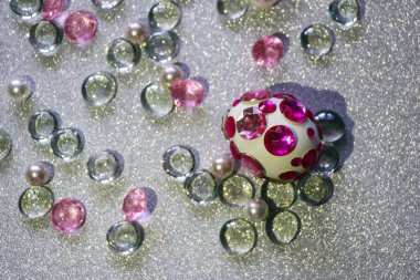 Paskalya kompozisyon flatlay. Paskalya yumurtaları Cam süsler ve inci boncuk gümüş bir arka plan üzerinde parlak rhinestones ile dekore edilmiştir.