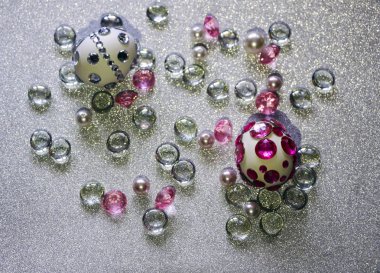 Paskalya kompozisyon flatlay. Paskalya yumurtaları Cam süsler ve inci boncuk gümüş bir arka plan üzerinde parlak rhinestones ile dekore edilmiştir.
