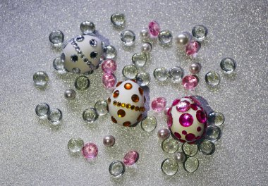 Paskalya kompozisyon flatlay. Paskalya yumurtaları Cam süsler ve inci boncuk gümüş bir arka plan üzerinde parlak rhinestones ile dekore edilmiştir.
