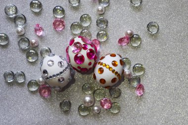 Paskalya kompozisyon flatlay. Paskalya yumurtaları Cam süsler ve inci boncuk gümüş bir arka plan üzerinde parlak rhinestones ile dekore edilmiştir.