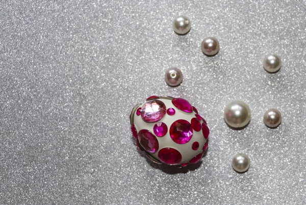 Paskalya kompozisyon flatlay. Paskalya yumurtaları Cam süsler ve inci boncuk gümüş bir arka plan üzerinde parlak rhinestones ile dekore edilmiştir.