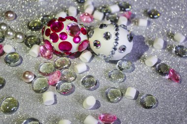 Paskalya kompozisyon flatlay. Cam süsler ve inci boncuklar ile Gümüş arka plan üzerinde parlak rhinestones Paskalya yumurtaları süslenmiş.