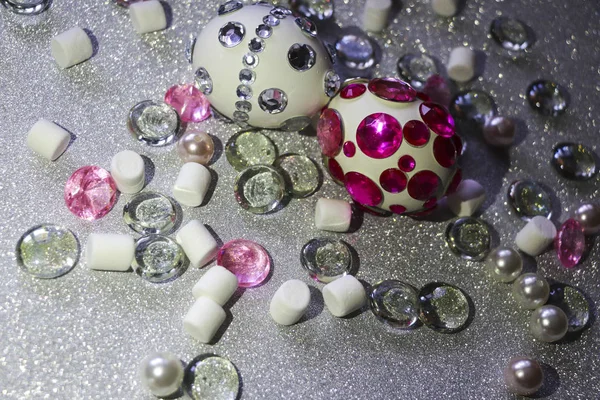 Composizione pasquale flatlay. Uova di Pasqua decorate con brillanti strass su sfondo argento con ornamenti in vetro e perle di perle . — Foto Stock