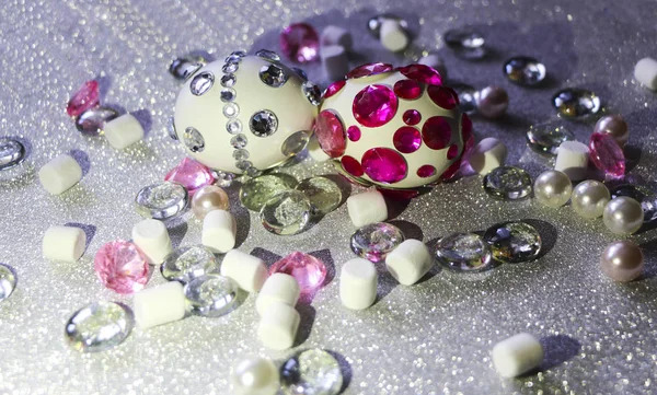 Easter composition flatlay. Easter eggs decorated with shiny rhinestones on  silver background with glass ornaments and pearl beads. — Stock Photo, Image