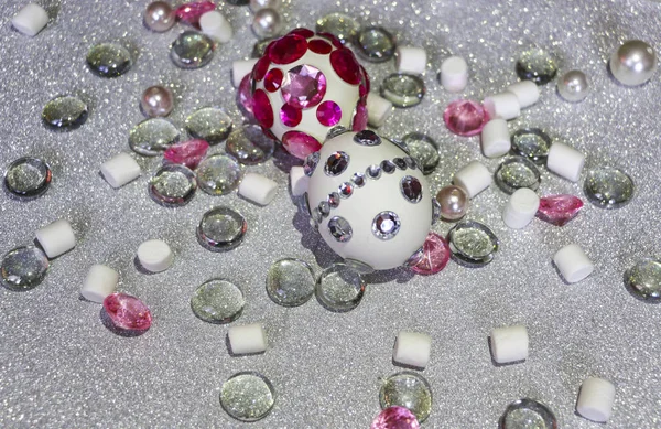 Easter composition flatlay. Easter eggs decorated with shiny rhinestones on  silver background with glass ornaments and pearl beads. — Stock Photo, Image