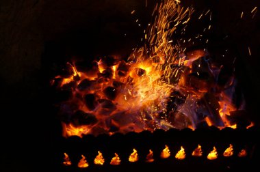 Odun kömürü ile parlak alev içinde demir mangal yakmak.