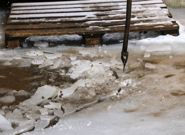 Eisenträger brechen das Eis, um das Wasser im Frühling bei Tauwetter und Flut abzuleiten. — Stockfoto