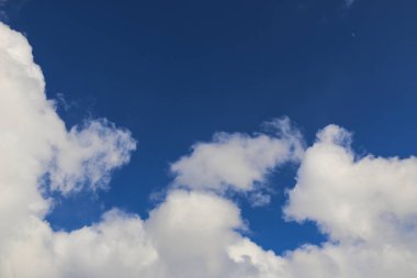 parlak mavi gökyüzü güneşli havalarda üzerinde beyaz kabarık bulutlar