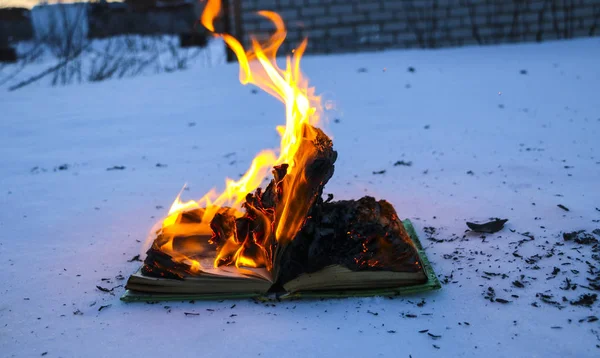 Brûler un livre dans la neige. pages avec le texte en livre ouvert graver wi — Photo