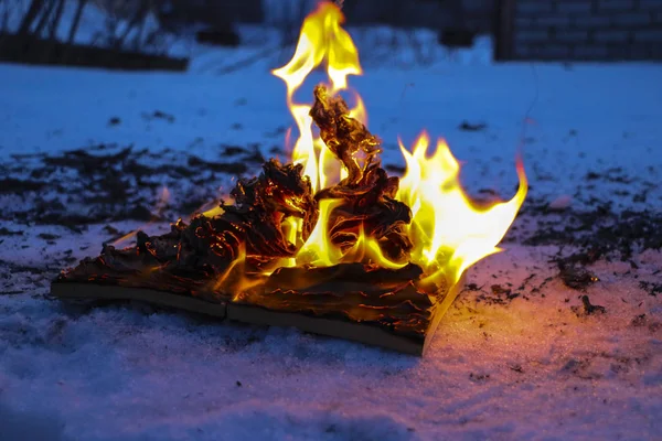 Buch im Schnee verbrennen. Seiten mit dem Text im offenen Buch verbrennen wi — Stockfoto