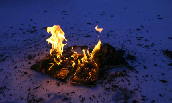 Burning book in  snow. pages with the text in  open book burn wi — Stock Photo, Image