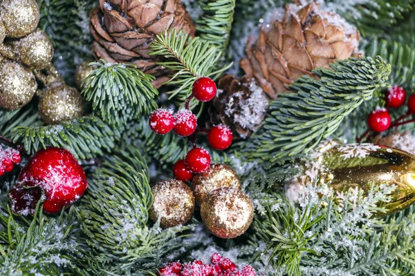 Composição de Natal de ramos de pinho, decorações de Natal douradas, bagas vermelhas e neve artificial . — Fotografia de Stock