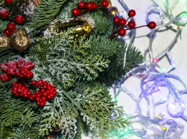 Composição de Natal de ramos de pinho, decorações de Natal douradas, bagas vermelhas e neve artificial . — Fotografia de Stock