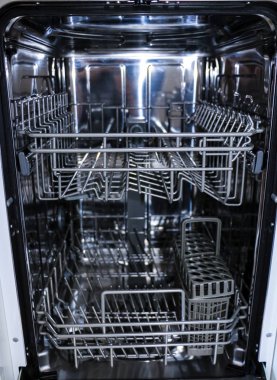 açık kapı ile bulaşık makinesi vardır. çatal bıçak takımı için yemek ve sepet dağıtımı için bulaşık makinesinin iç rafları.