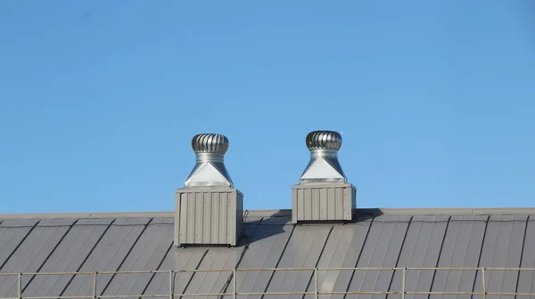 Γυαλιστερό μεταλλικό αέρα εξαερισμού στην οροφή περιστρέφεται για να καθαρίσει τον αέρα στην οικοδόμηση και τη ρύθμιση της θερμοκρασίας. — Φωτογραφία Αρχείου