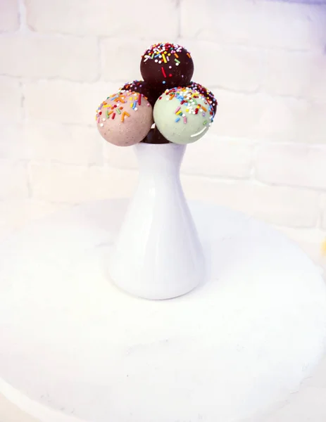 Delicious cake with icing and colorful dressing on stick in white vase. — Stock Photo, Image