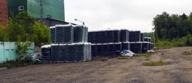 Temiz şişelerin bitmiş ürünleri paletler halinde paketlenir. Şişeli raflar ormanın yakınındaki cam fabrikasının yakınındaki terk edilmiş alanda.