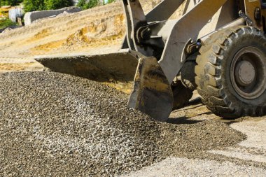  traktör çakıl ile kepçe toplar. beton karışımı için ekskavatör ayıklar kum ve çakıl.