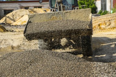  traktör çakıl ile kepçe toplar. beton karışımı için ekskavatör ayıklar kum ve çakıl.