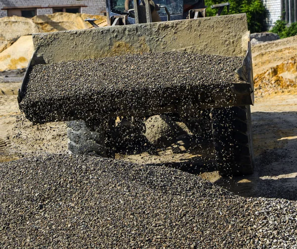 Traktor mengumpulkan sendok dengan kerikil. ekskavator mengekstrak pasir dan kerikil untuk campuran beton . — Stok Foto