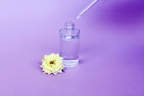 Botella de vidrio con pipeta con aceite o suero, con flor de rosa blanca sobre fondo delicado. Concepto: bio cosméticos orgánicos, aceites vegetales, colágeno sérico, cuidado de la piel —  Fotos de Stock