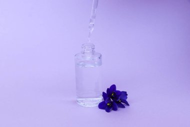 koku ve çiçek tadı ile yükselen elektronik sigara için pipet ile şeffaf şişe sıvı, metin için alan ile pembe arka plan üzerinde.