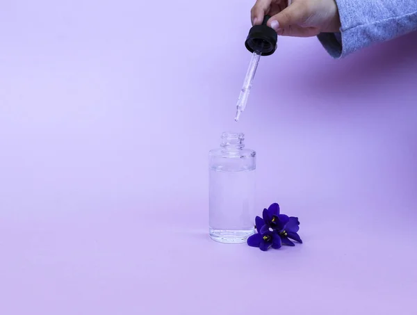 Рідина в прозорій пляшці з піпеткою для стрижки електронних сигарет з ароматом і смаком квітів, на рожевому фоні з простором для тексту . — стокове фото