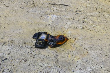 dokusal beton arka plan üzerinde yanmış cep telefonları. Konsept: Düşük kaliteli cep telefonları kullanma tehlikesi.