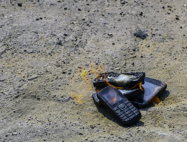 Спалені мобільні телефони на текстовому бетонному фоні. Концепція: небезпека використання низькоякісних мобільних телефонів . — стокове фото