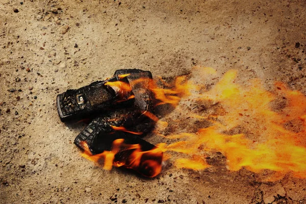 在纹理混凝土背景上烧坏的手机。概念：使用低质量手机的危险. — 图库照片