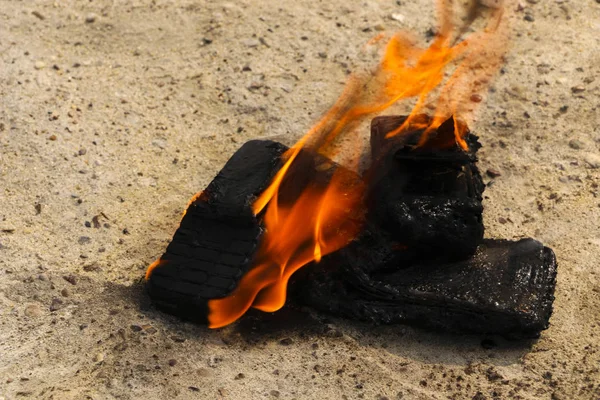 Telefoni cellulari bruciati su sfondo di cemento strutturato. Concetto: pericolo di utilizzare telefoni cellulari di bassa qualità . — Foto Stock