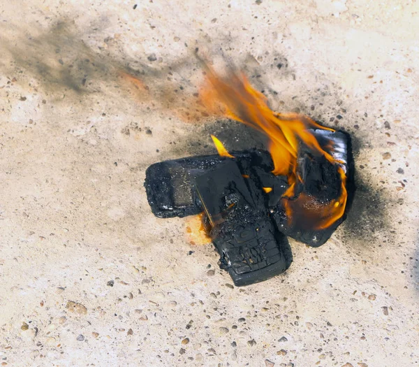 在纹理混凝土背景上烧坏的手机。概念：使用低质量手机的危险. — 图库照片