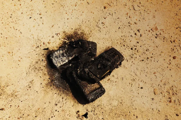 burnt mobile phones on textural concrete background. Concept: Danger of using low-quality cell phones.