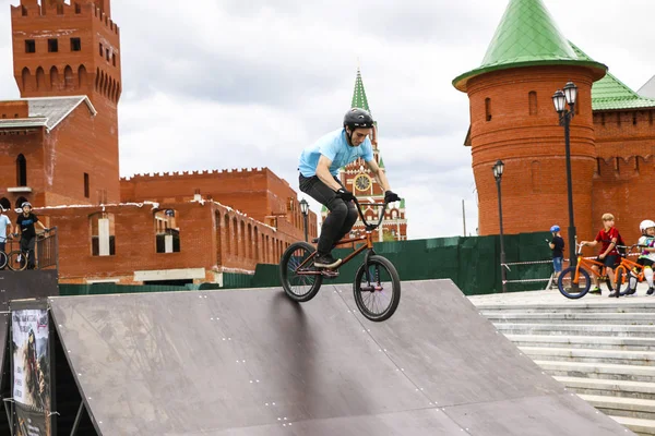 YOSHKAR-OLA, RUSSIA, AGOSTO 10, 2019: adolescentes realizam saltos e acrobacias interessantes em bicicletas de saltos de esqui e rampas em uma cidade de skate . — Fotografia de Stock