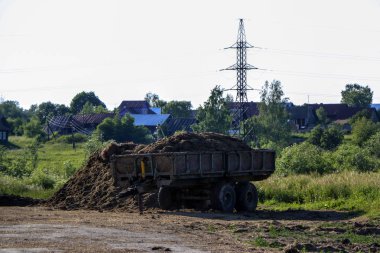 Gübreli eski paslı karavan gübre ekmeden önce toprağı gübrelemek için tarlada duruyor..