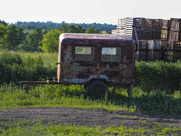 Vieille remorque rouillée avec engrais fumier se tient dans le champ pour fertiliser les terres avant de semer . — Photo