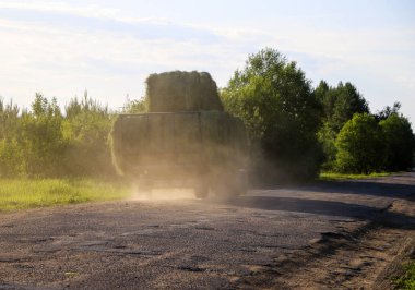 Traktör, mevsimlik hasattan sonra samanı yuvarladı.