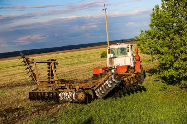 春天里 拖拉机在一个大田里犁地 准备种植庄稼的土壤 用拖拉机用圆盘犁犁土 — 图库照片