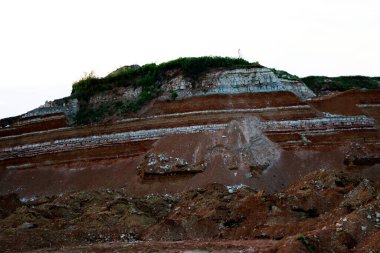 Toprağın jeolojik çalışmalarından sonra yer altındaki kil taş ocaklarının çeşitli katmanlarının dokuları. Toprağın bir bölümünde renkli kil ve taş katmanları, farklı kaya oluşumları ve toprak katmanları..