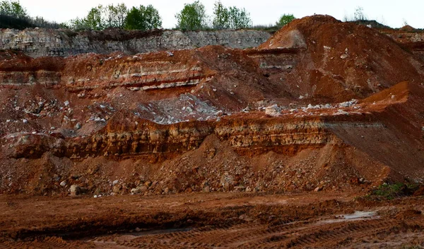 textures of various clay layers underground in  clay quarry after  geological study of the soil. colored layers of clay and stone in  section of the earth, different rock formations and soil layers.