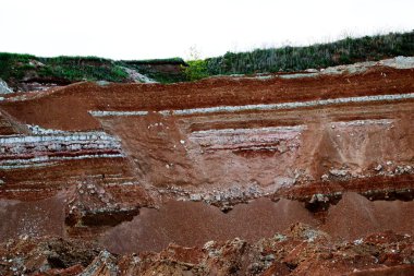 Toprağın jeolojik çalışmalarından sonra yer altındaki kil taş ocaklarının çeşitli katmanlarının dokuları. Toprağın bir bölümünde renkli kil ve taş katmanları, farklı kaya oluşumları ve toprak katmanları..