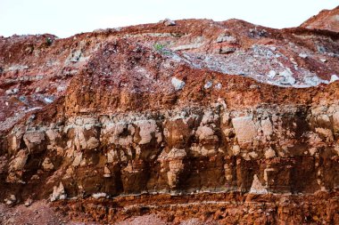 Toprağın jeolojik çalışmalarından sonra yer altındaki kil taş ocaklarının çeşitli katmanlarının dokuları. Toprağın bir bölümünde renkli kil ve taş katmanları, farklı kaya oluşumları ve toprak katmanları..