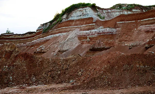 textures of various clay layers underground in  clay quarry after  geological study of the soil. colored layers of clay and stone in  section of the earth, different rock formations and soil layers.