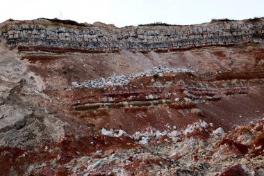 Toprağın jeolojik çalışmalarından sonra yer altındaki kil taş ocaklarının çeşitli katmanlarının dokuları. Toprağın bir bölümünde renkli kil ve taş katmanları, farklı kaya oluşumları ve toprak katmanları..