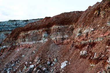 Toprağın jeolojik çalışmalarından sonra yer altındaki kil taş ocaklarının çeşitli katmanlarının dokuları. Toprağın bir bölümünde renkli kil ve taş katmanları, farklı kaya oluşumları ve toprak katmanları..
