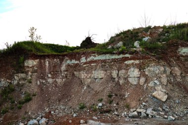 Toprağın jeolojik çalışmalarından sonra yer altındaki kil taş ocaklarının çeşitli katmanlarının dokuları. Toprağın bir bölümünde renkli kil ve taş katmanları, farklı kaya oluşumları ve toprak katmanları..